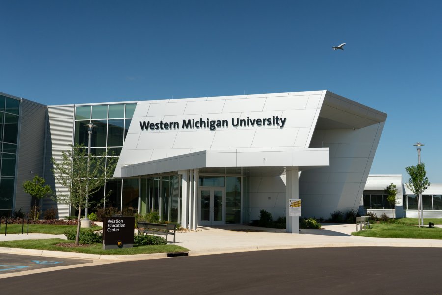 Entrance to the Aviation Education Center in Battle Creek, Michigan on a sunny day with blue skies and a plane taking off in the distance.