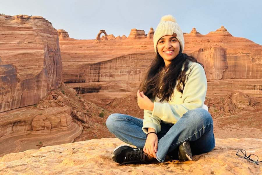 An international student poses in the desert.
