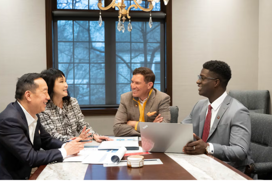 Zhang Financial Presidential Internship recipient sitting with President Kavalhuna and the Zhangs