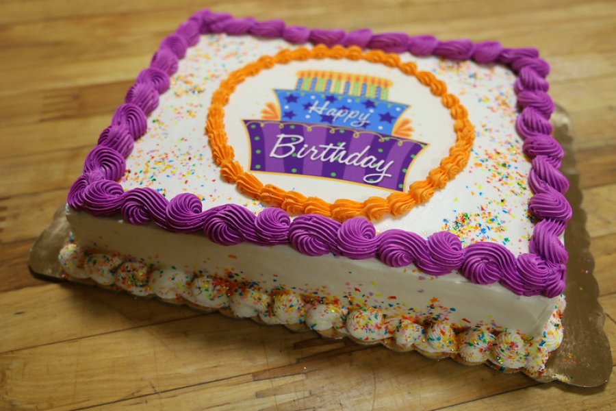 Celebration cake decorated with a "Happy Birthday" edible image and piped frosting on the edges.