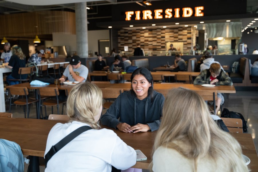 Students chatting and eating within the dining center. 