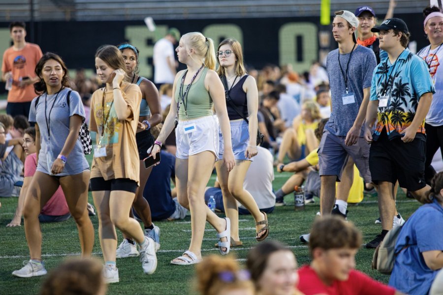 students walking on football field at fall welcome