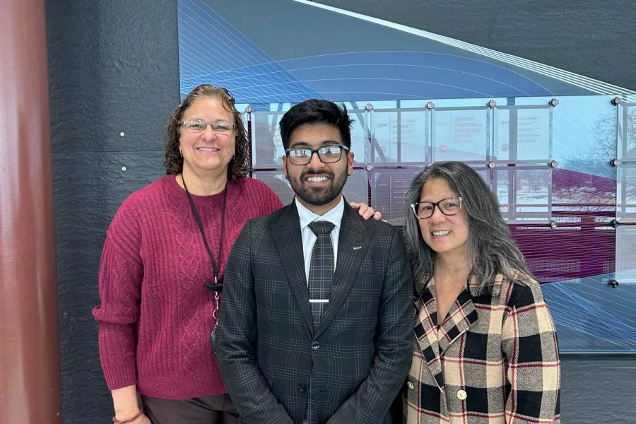 An international student poses with his advisors and friends during graduation season.