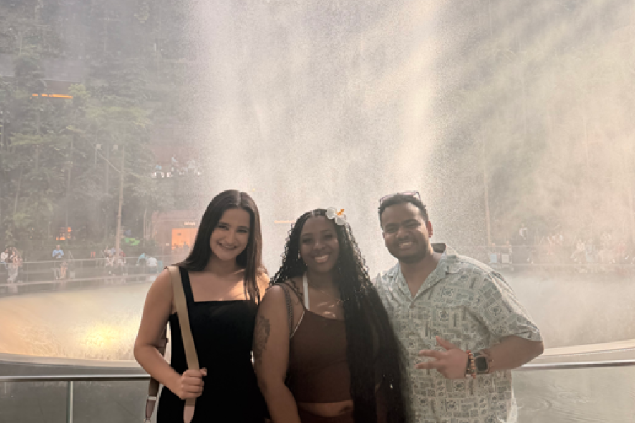 Three WMU study abroad students stand in front of a large fountain at the Singapore airport.