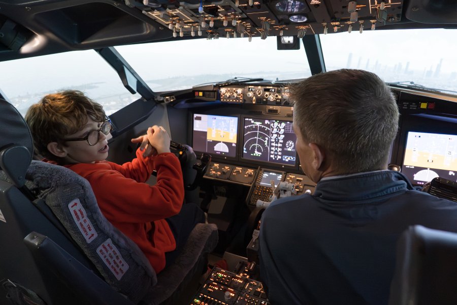 Vail Fear and Nic Rowe sit in a 737 MAX flight simulator.