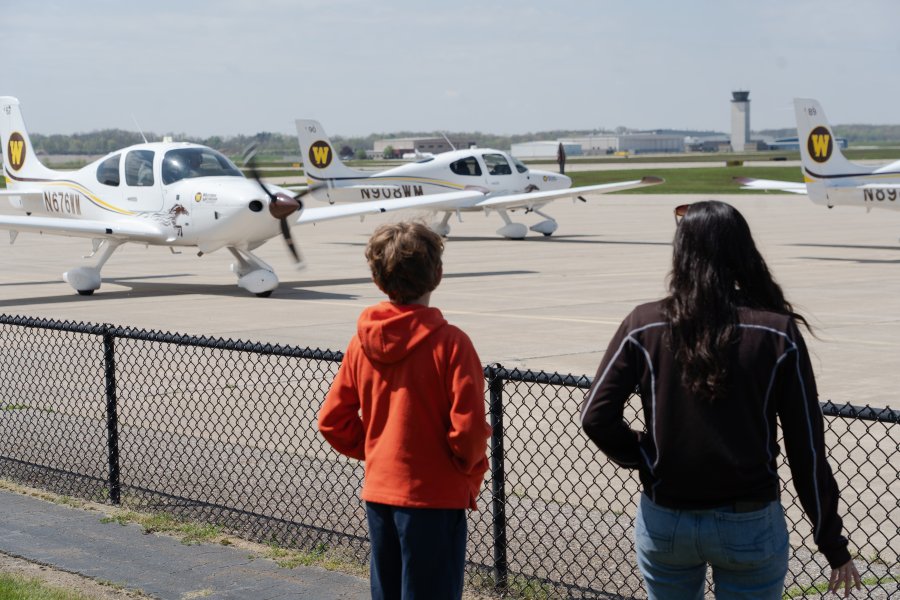 Vail Fear and Bella Kwartnik look at planes on the tarmac.