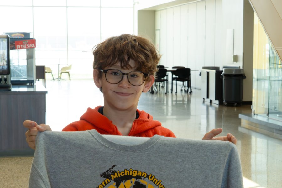 Vail Fear holds up a College of Aviation sweatshirt.