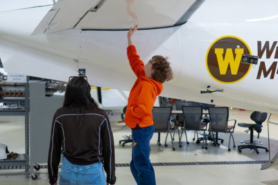 Vail Fear jumps up to touch a plane's wing.