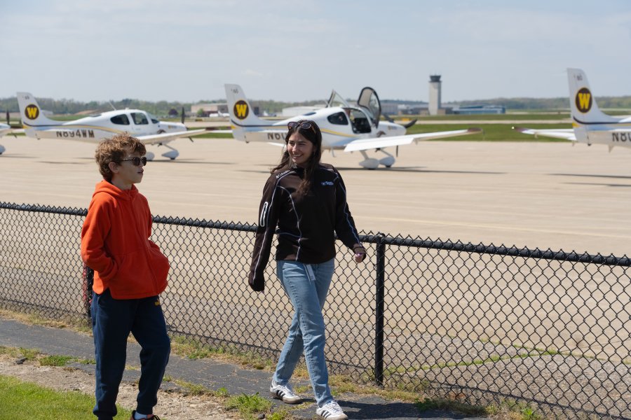 Vail Fear walks next to Bella Kwartnik on the airport tarmac.