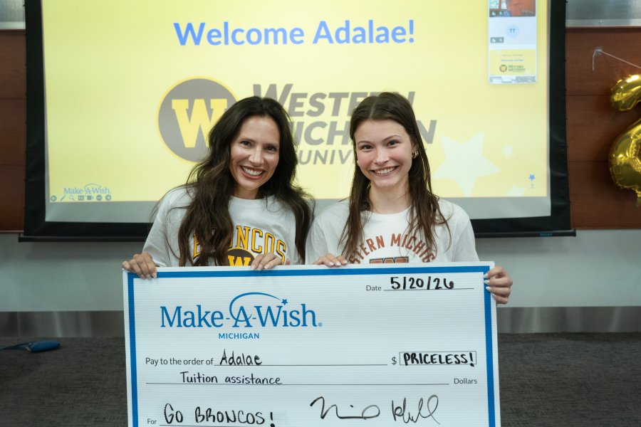 Grand Rapids high school student Adalae and her mom hold a large check from Make-A-Wish.