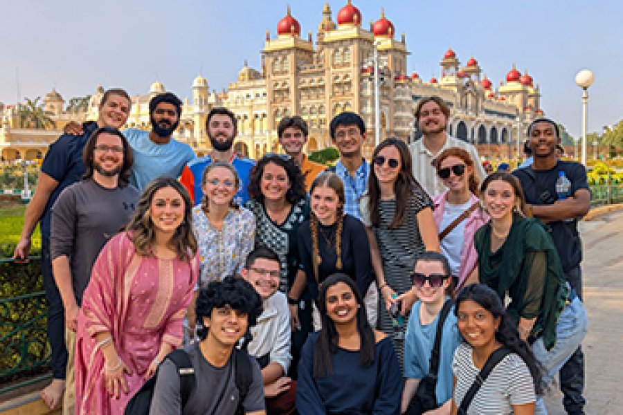 A group of students in front of a historical buildings
