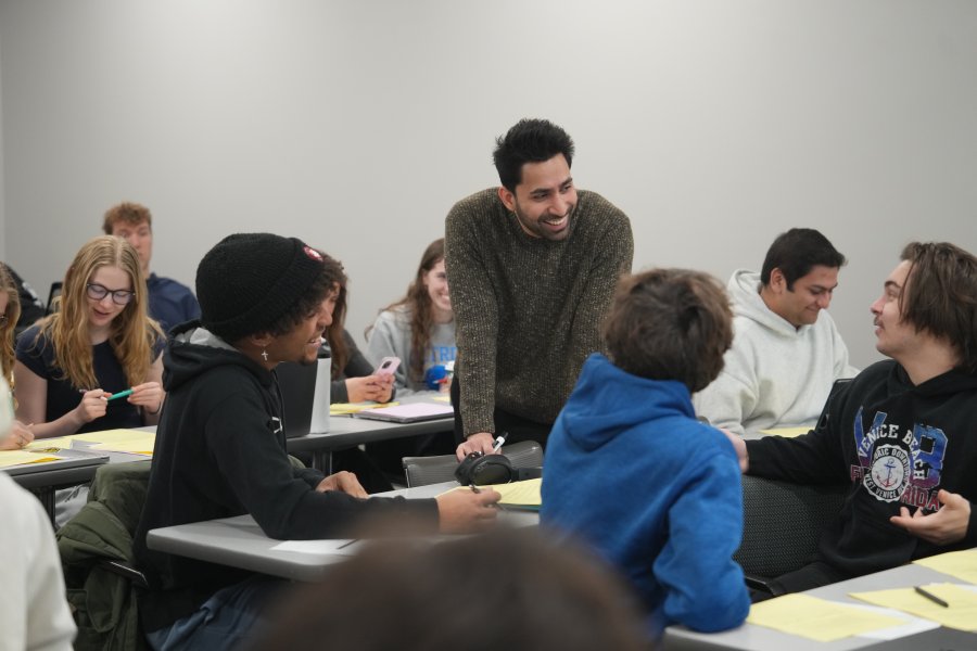 A professor talks to students in the classroom.