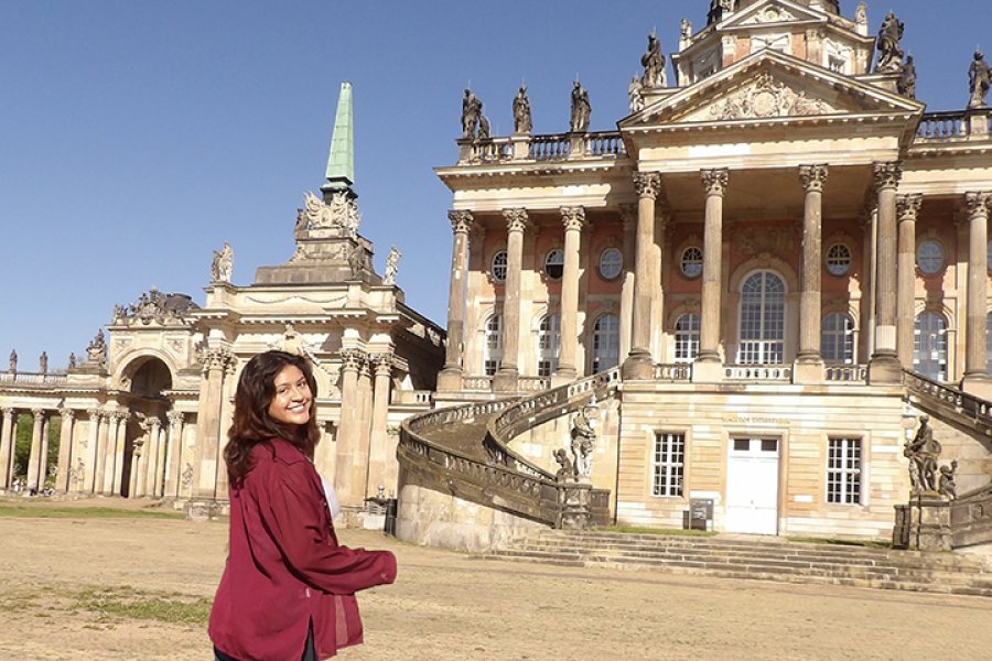 A student standing in front of a historical building