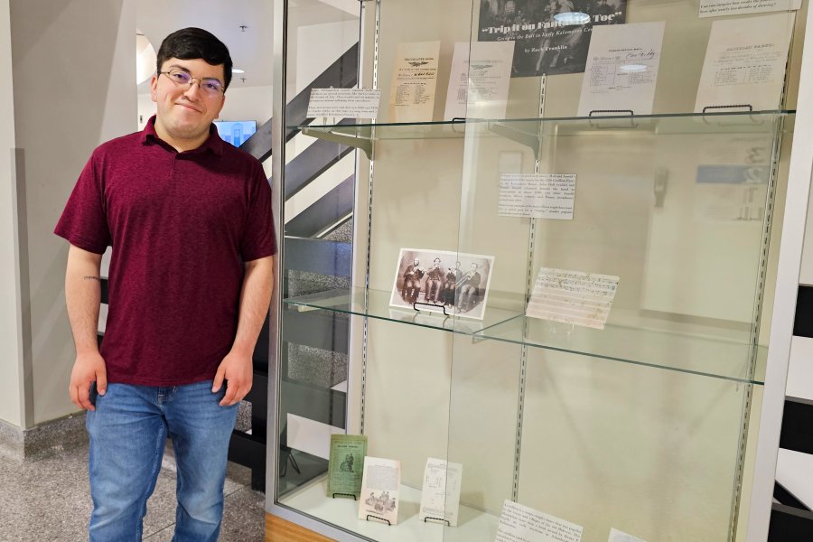 Western Michigan University student Zach Fanklin working on exhibit case about Trip it on Fantastic Toe: Going to the Ball in Early Kalamazoo County.