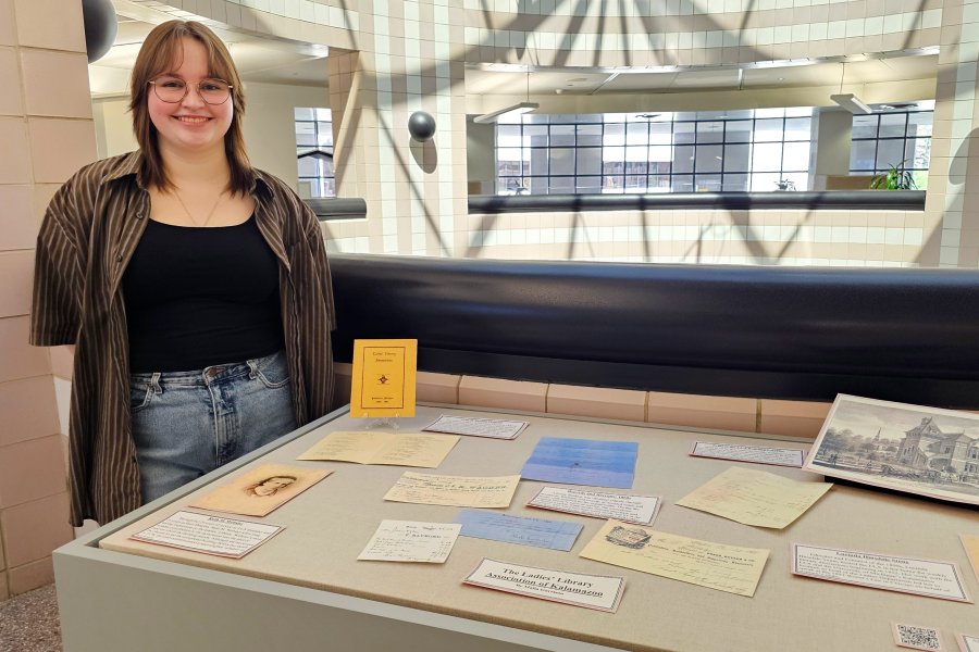 Western Michigan University student Malia Garrison working on exhibit case about The Ladies' Library Association of Kalamazoo.