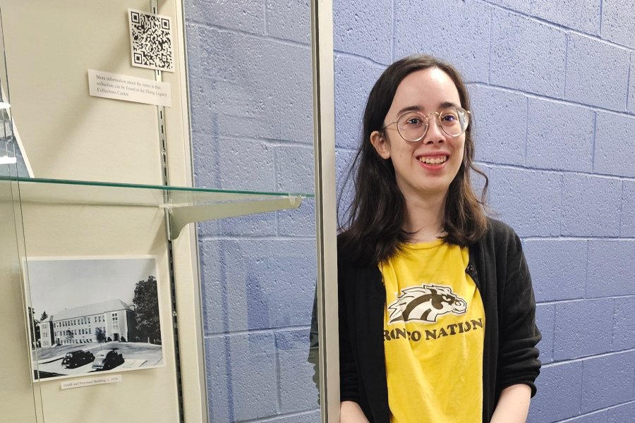 Western Michigan University student Meena Jacobs working on exhibit case about Western State Normal School titled "The Quad of Yore".