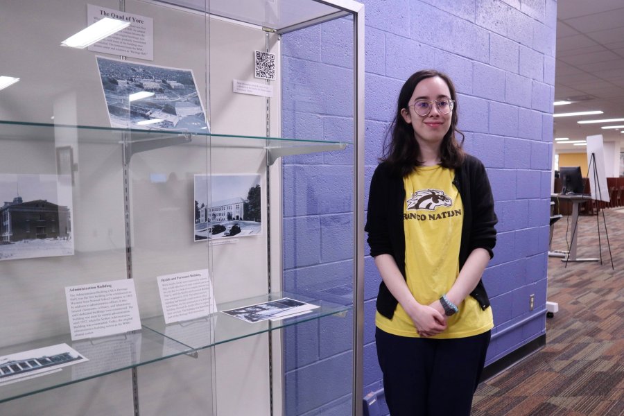 Western Michigan University student Meena Jacobs working on exhibit case about Western State Normal School titled The Quad of Yore.