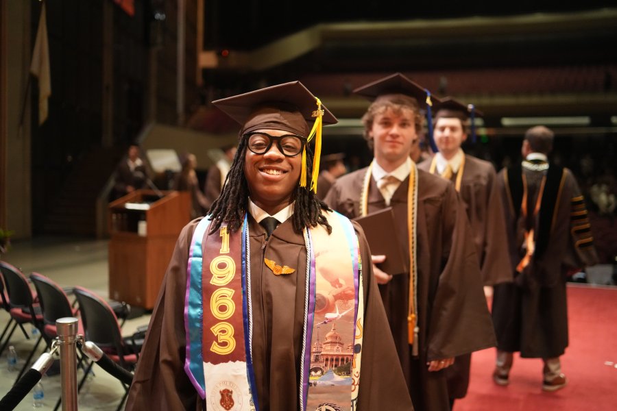 Raymond Miller walks across the commencement stage.