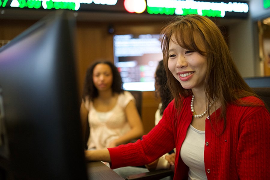 A woman sitting in front of a computer in the Greenleaf Trust Trading Room