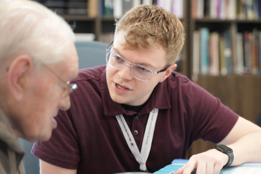 Speech student working with older man.