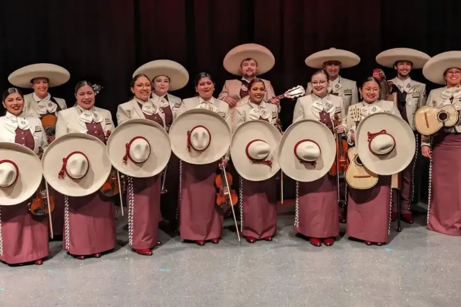 A mariachi band in maroon outfits.