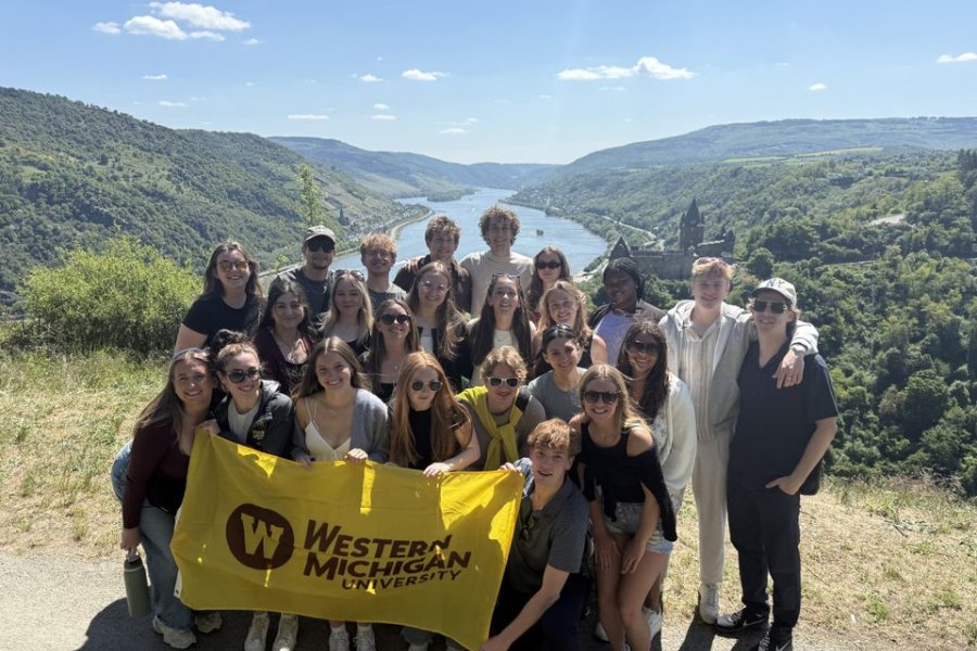 Students with the WMU Flag in front of a scenic view