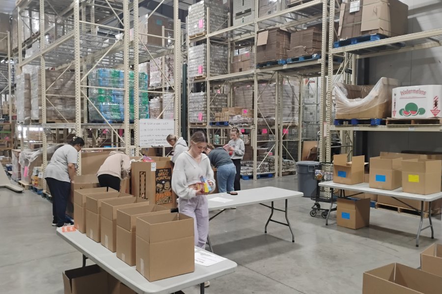 WMU student volunteers working in the warehouse at Kalamazoo Loaves and Fishes, preparing groceries for area residents.