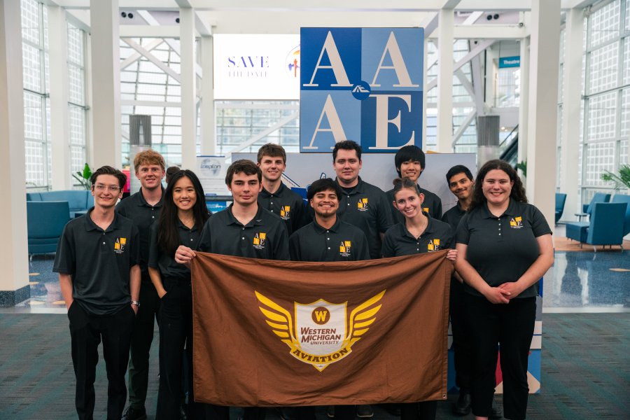 Students standing with flag at AAAE conference.