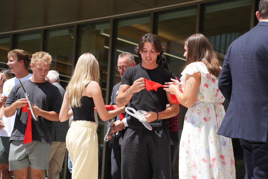 Students hold pieces of red ribbon from the ribbon-cutting ceremony.