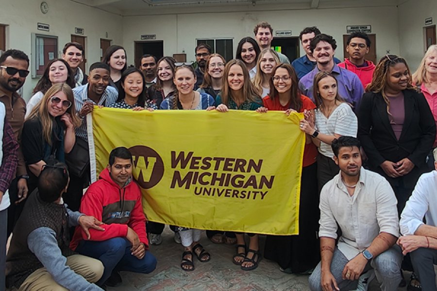 Study abroad india trips holding a flag in a group