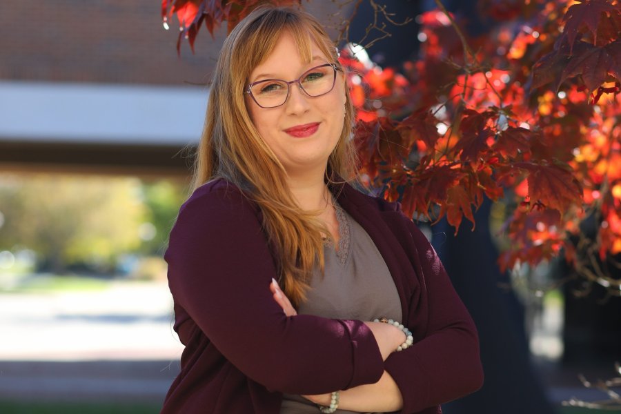 Student Success Coach Adysen with red leaves behind her. 