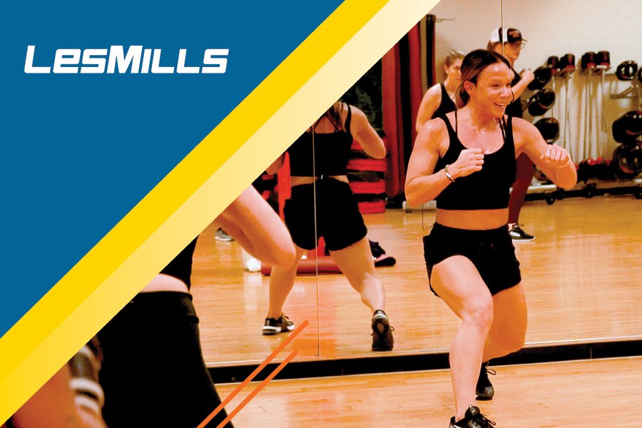 A group fitness instructor instructing a group in front of a mirror.