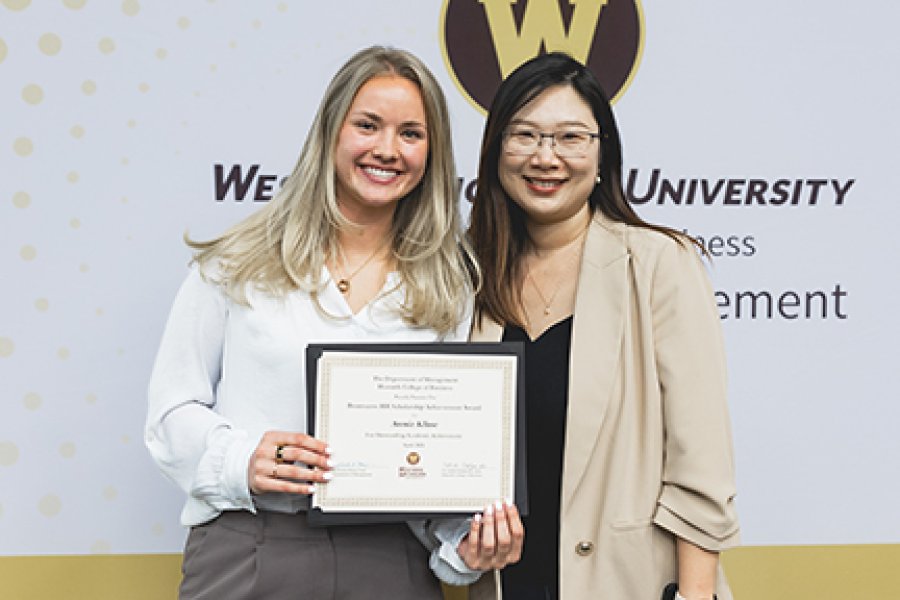 A student and her professor receiving a scholarship