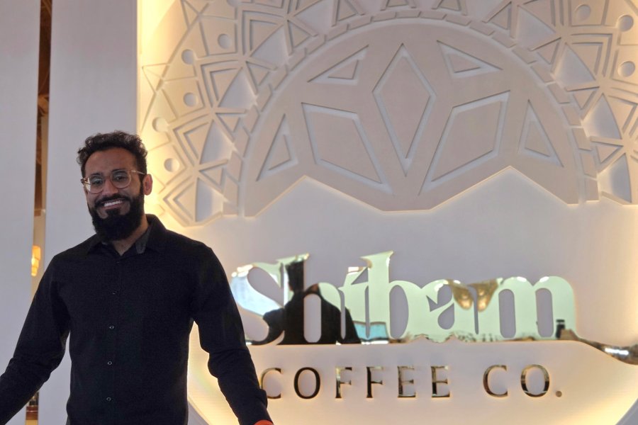 Talal Arshad, Western Michigan University alumnus and local business owner, smiles for a portrait in Shibam Coffee Co., the Yemeni coffee shop he established in Kalamazoo