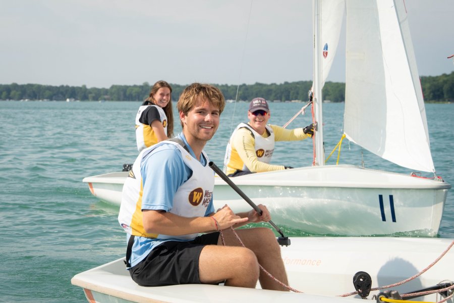 WMU student sailing on the open water in a WMU uniform.