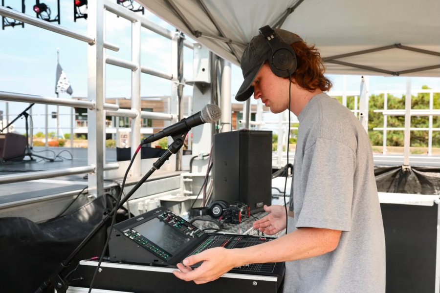 Aiden Lambert wears headphones at an audio mixer.
