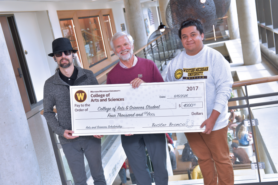 Students hold completion scholarship check