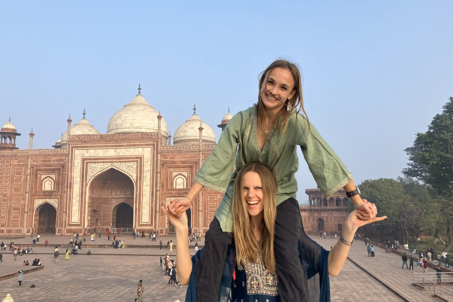 Two students pose by a landmark in India as part of a WMU Study Abroad. They wear tradition Indian dress.
