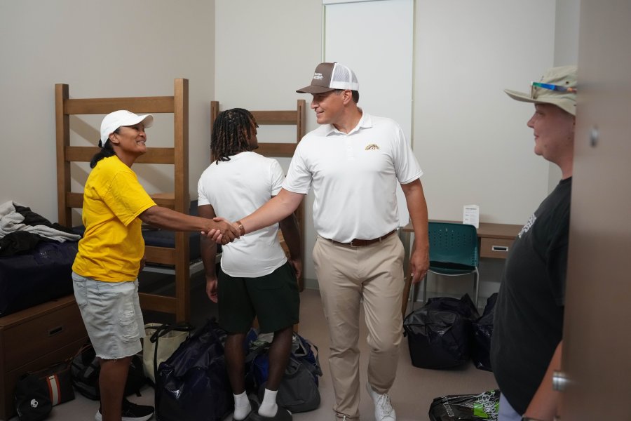 President Russ Kavalhuna shakes a parent's hand.