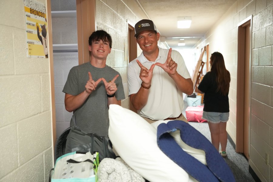 President Russ Kavalhuna takes a photo with a student during move-in.