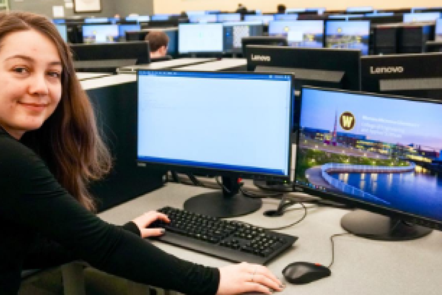 Student sitting in front of a computer in a computer lab