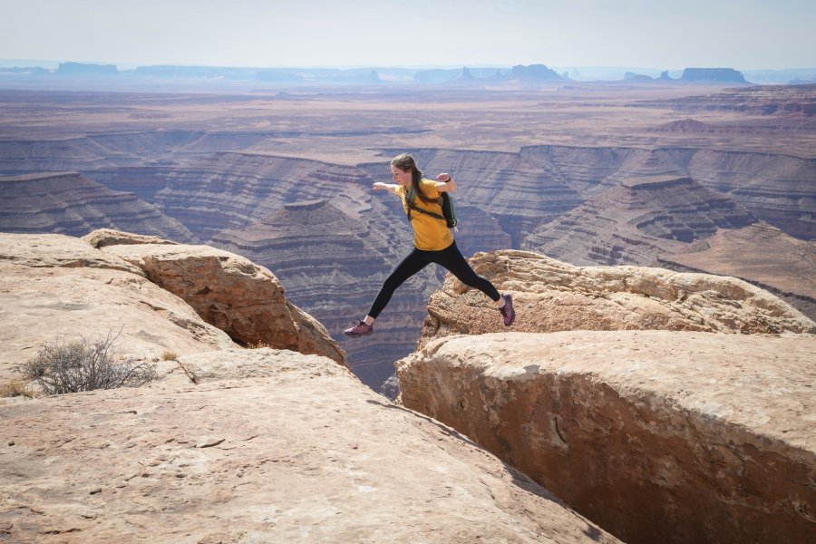 An honors student on the Desert Southwest trip jumps across a small crevasse from one rock to another.