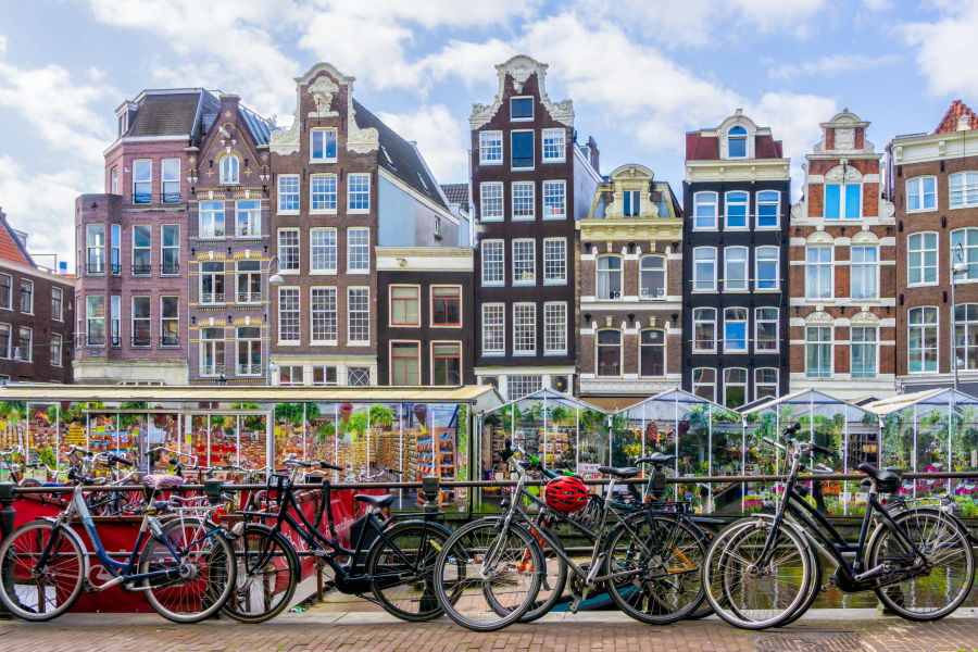 City landscape of colorful Amsterdam buildings with bikes in front. 