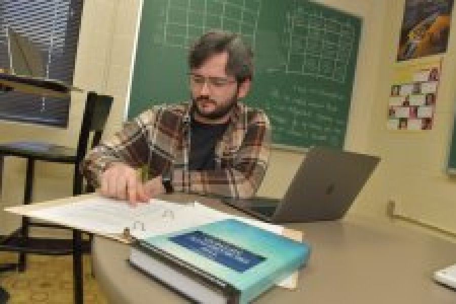 Student studying math with a laptop and books