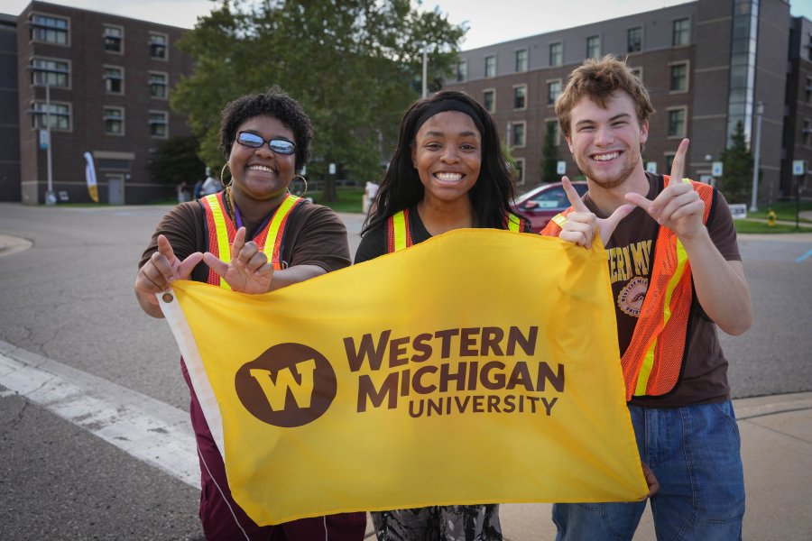 Students on traffic duty hold a Western Michigan University flag.