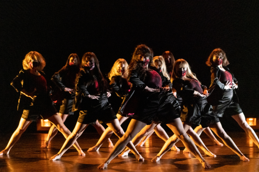 a group of woman wearing masks in a unison dance pose.