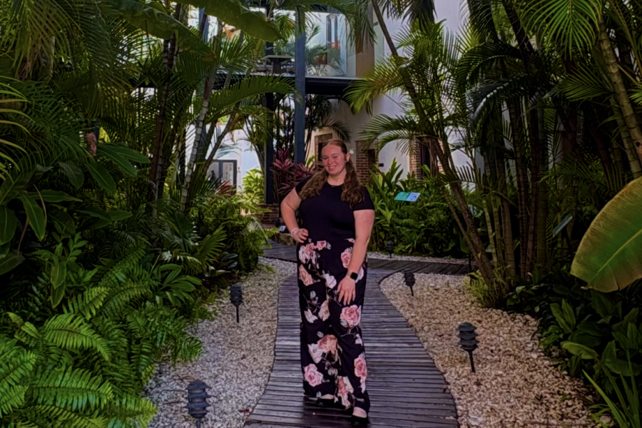 WMU study abroad student, Sara Stokely, stands for a photo on a path in front of palm trees in the Dominican Republic. 