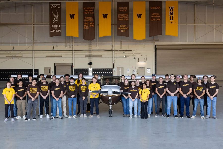 WMU’s Sky Broncos 2026 regional championship team poses with a WMU airplane. 