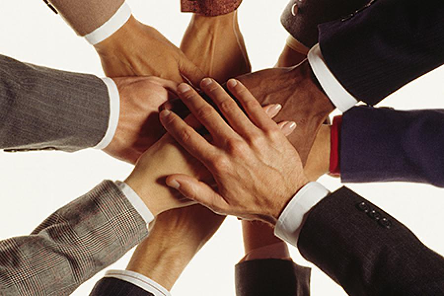 Photo of several hands stacked together.