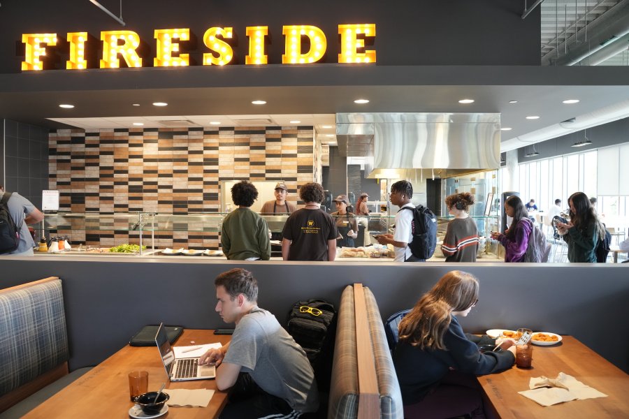 Students sit at tables in booths in front of the counter at Fireside in the WMU Student Center Dining facility.